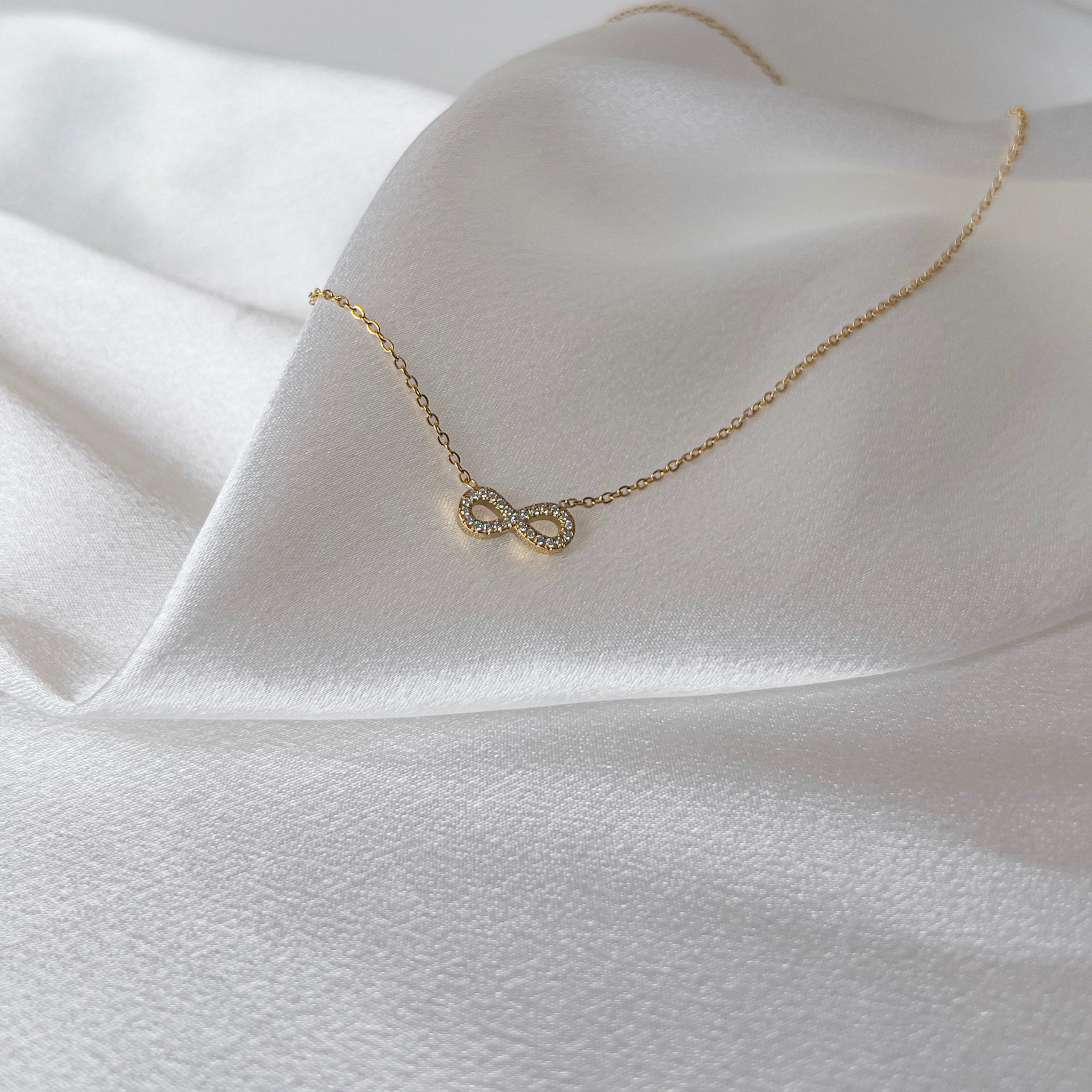 Infinité Necklace | Gold Crystal Infinity Pendant — detail view — TJAURI jewelry