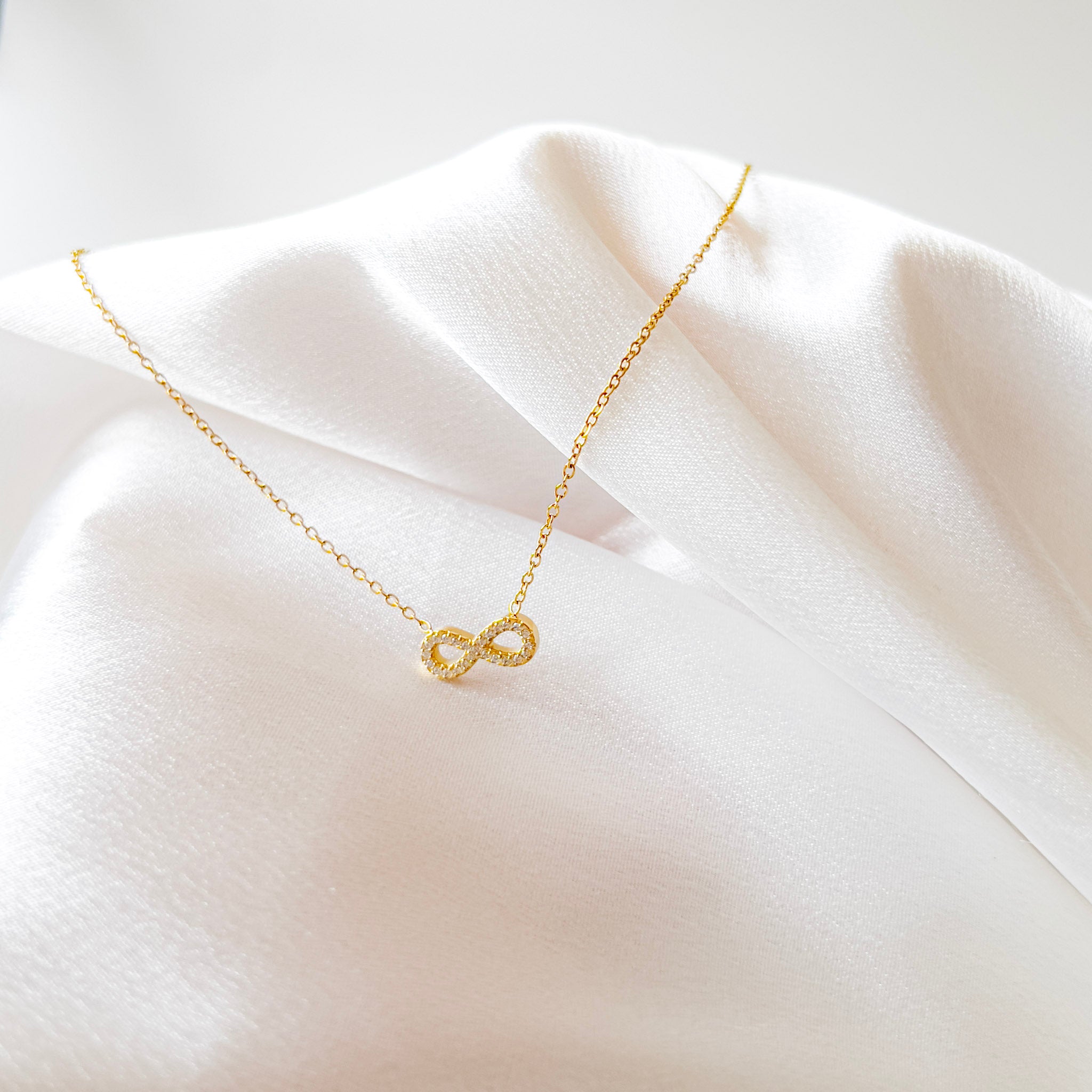 Infinité Necklace | Gold Crystal Infinity Pendant — detail view — TJAURI jewelry